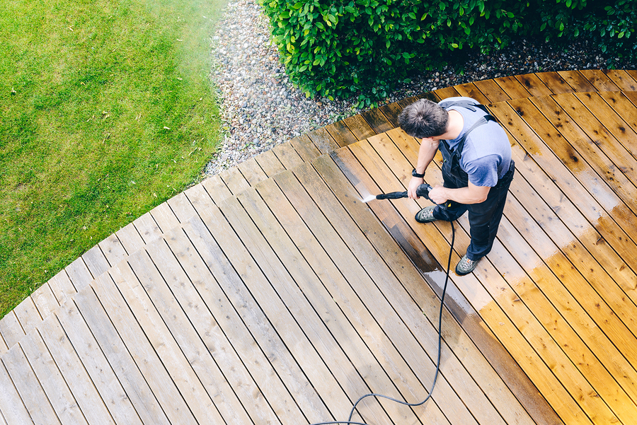 cleaning terrace with a power washer - high water pressure cleaner on wooden terrace surface