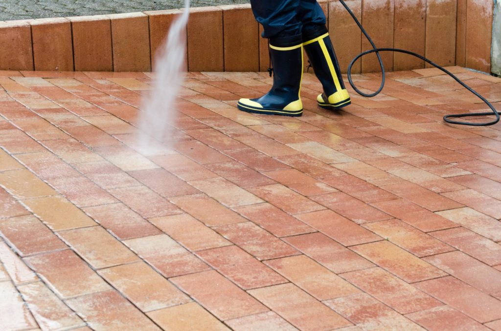 someone cleaning the concrete walkway